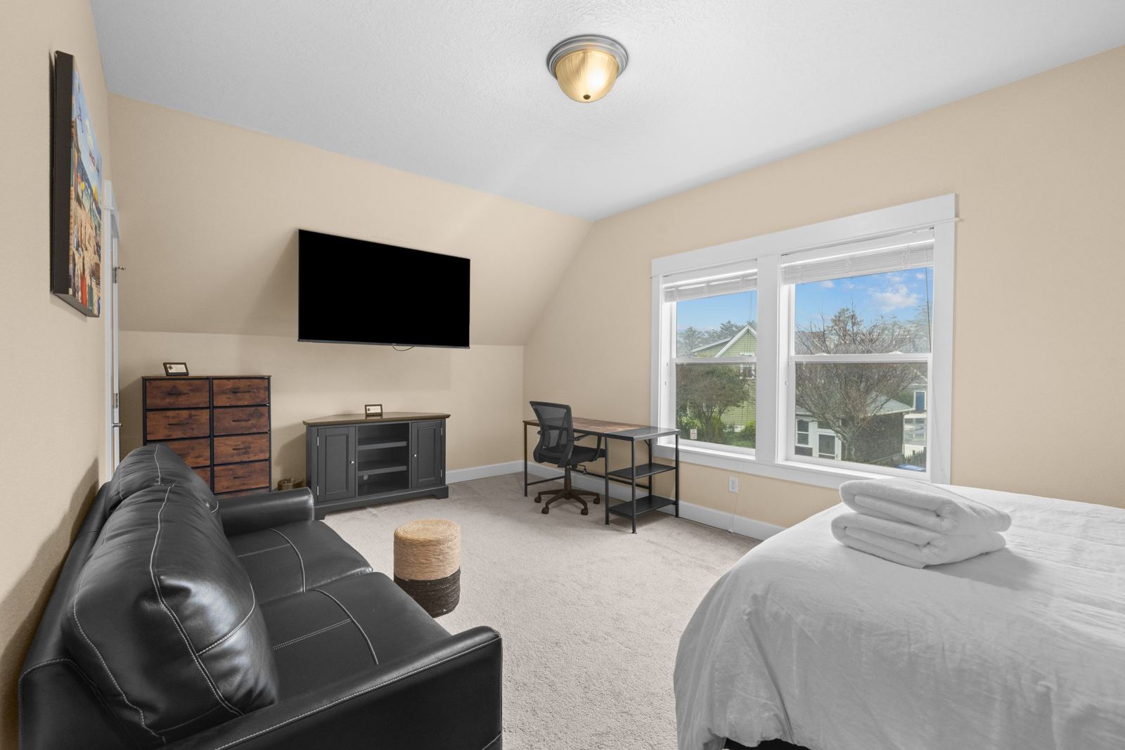 Upstairs bedroom with leather sleeper sofa and TV